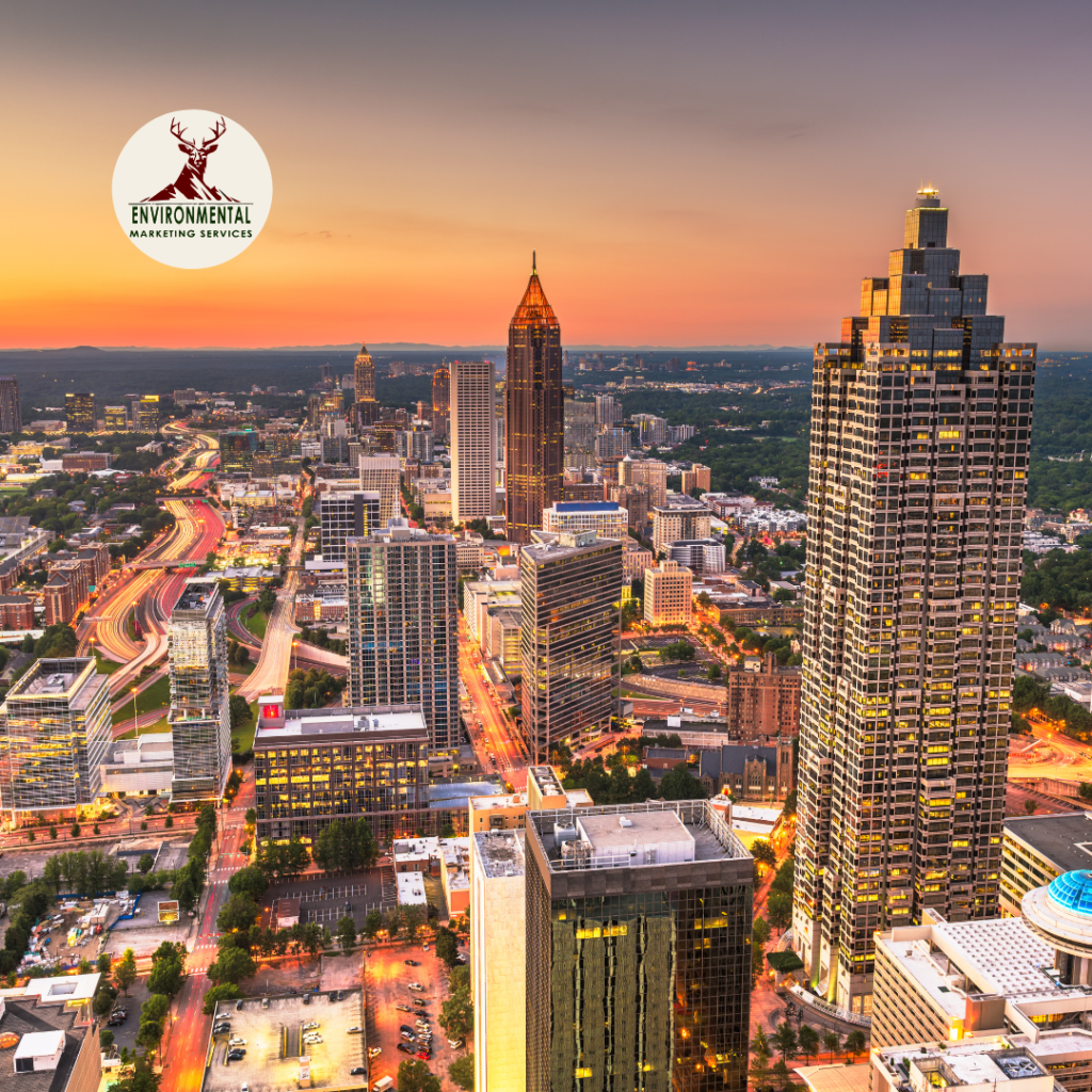 Aerial view of Atlanta's skyline at sunset, showcasing tall buildings and city lights.