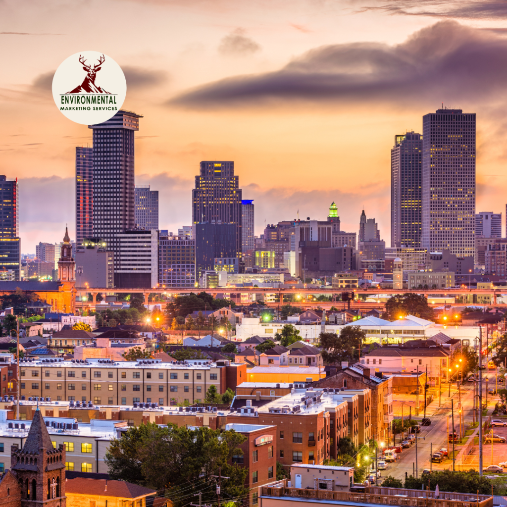 A sunset view of the New Orleans skyline featuring tall skyscrapers, historic buildings, and street lights